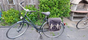 Degelijke damesfiets met bagagedrager en fietstassen