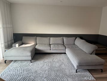Grote U-vormige bank met chaise longue en ottoman