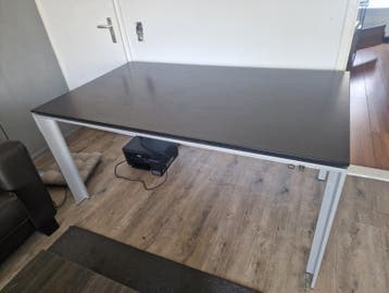 Moderne eettafel met zwart blad en metalen poten