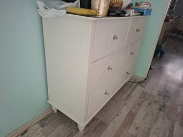 Witte ladekast met sierlijke handgrepen
