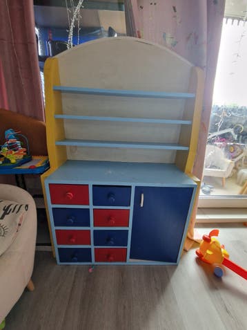 Kleurrijke kinderopbergkast met planken en lades