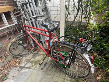 Oude rode fiets met bagagedragers