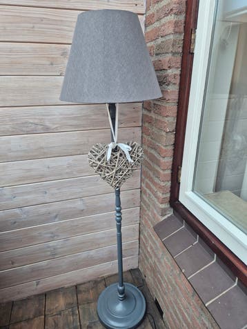 Grijze staande lamp met stoffen kap en hartdecoratie