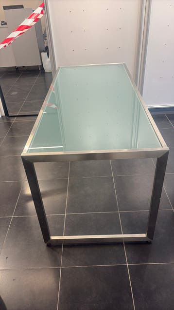 Moderne tafel met glazen blad en metalen onderstel