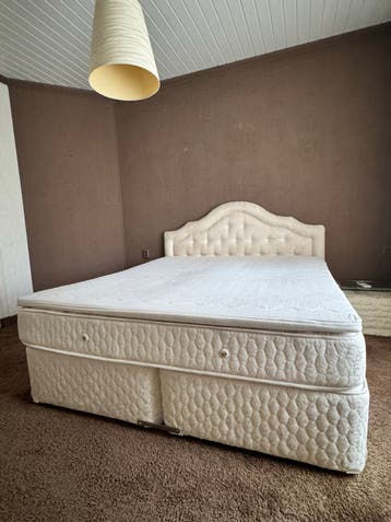 Comfortabel tweepersoonsbed met gestoffeerd hoofdbord