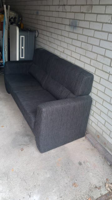 Salontafel en donkerblauwe 2,5 zits bank met krabschade