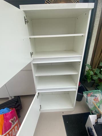 Witte kast met planken en deuren