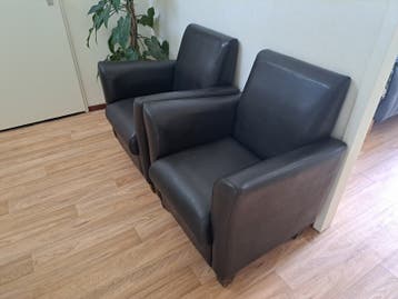 Twee comfortabele donker bruin fauteuils