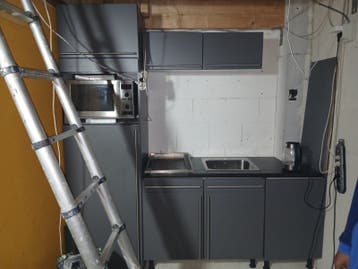 Compacte grijze keuken met spoelbak en kookplaat