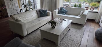 Wit lederen bankstellen en houten salontafel