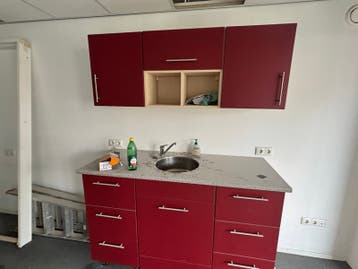 Compacte rode keuken met spoelbak en opbergruimte