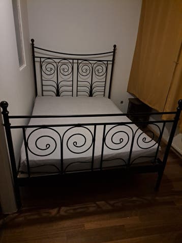Zwart metalen tweepersoonsbed met sierlijke krullen