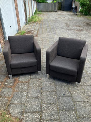Twee bruine fauteuils met aluminium poten