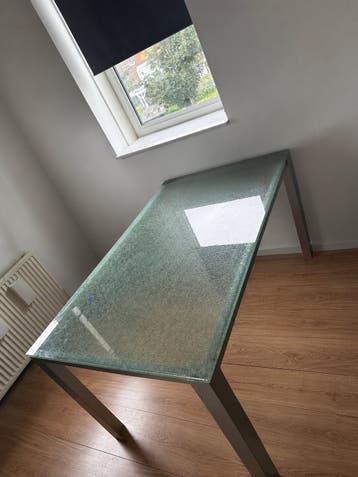 Moderne glazen eettafel met metalen onderstel