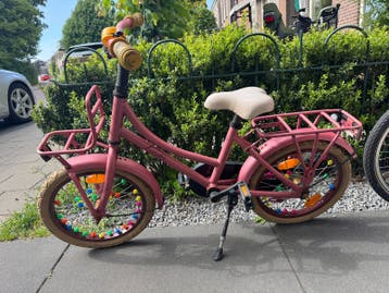 Roze kinderfiets, altijd buiten gestaan, doet het prima