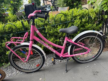Roze kinderfiets met lekke achterband