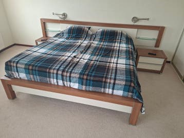 Tweepersoonsbed met nachtkastjes en hoofdbord