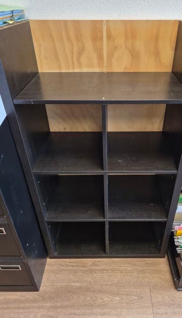 Zwart houten kastje met vakken, verzaagd