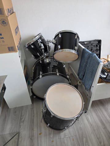 Zwart drumstel met bekkens en muziekstandaard