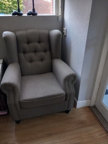 Comfortabele grijze fauteuil met knoopdetails