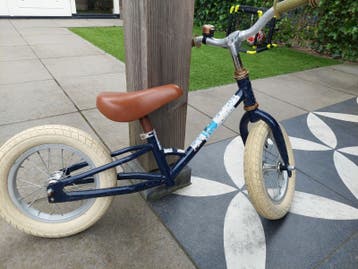 Stoere blauwe loopfiets met bruin zadel