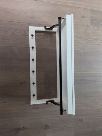 Witte wandkapstok met zwarte haken en stang