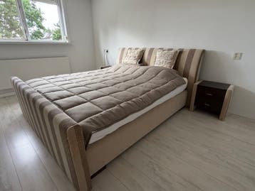 Comfortabel tweepersoonsbed met gestreepte bekleding