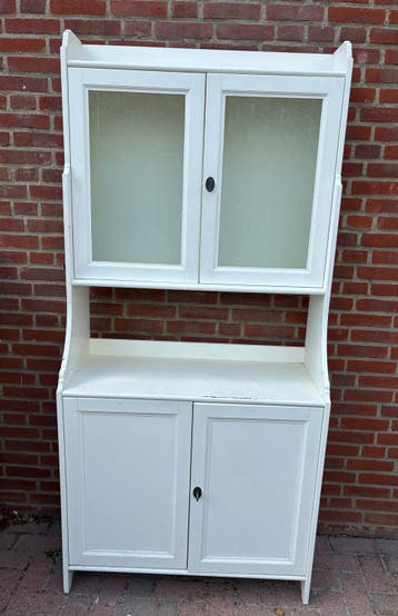 Witte buffetkast met glazen en dichte deuren