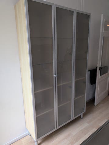 Hoge kast met glazen deuren en planken