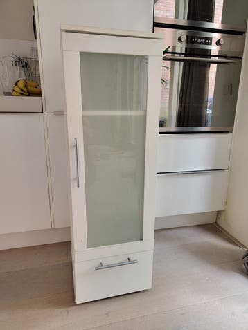 Witte smalle kast met planken en lade
