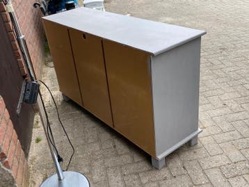 Grijze kast met lades en glazen schuifdeuren