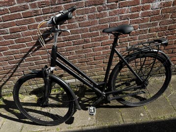 Oude zwarte stadsfiets (terugloop kapot)