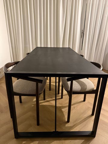 Moderne zwarte eettafel met metalen onderstel