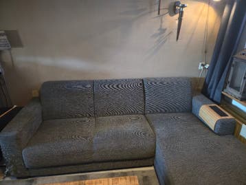 Grijze hoekbank met chaise longue en gebruikssporen