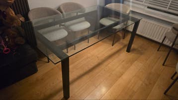 Moderne glazen eettafel met zwarte poten