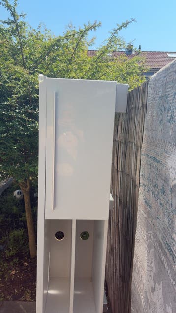 Witte smalle kast met deuren en open vakken