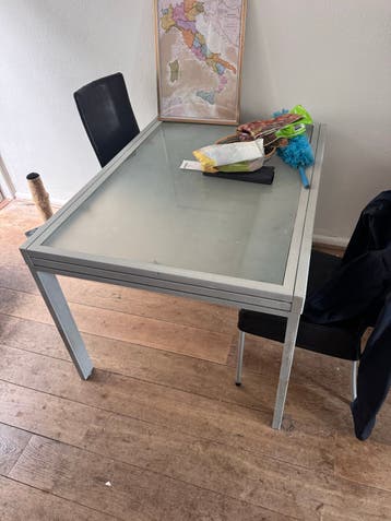 Eettafel met glazen blad en metalen frame