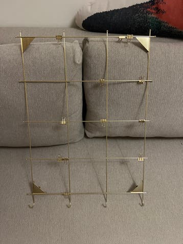 Gouden metalen wandrek met haken