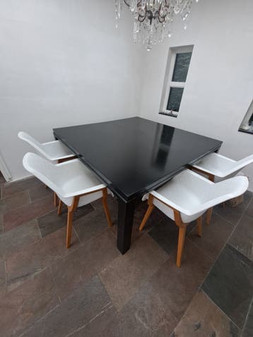 Zwarte vierkante houten eettafel.