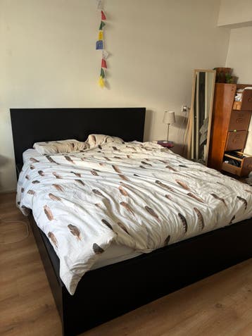 Zwart tweepersoonsbed met lades