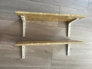 Twee houten planken met witte beugels