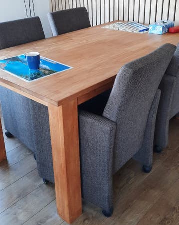 4 bruine stoffen eetkamerstoelen.