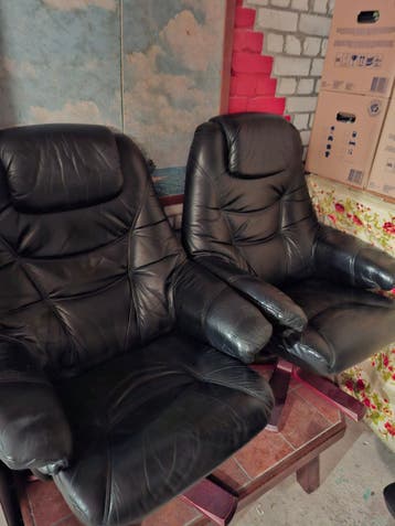 2 leren relaxstoelen met voetenbankjes