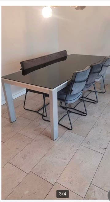 Eettafel met glazen blad en lichte gebruikssporen