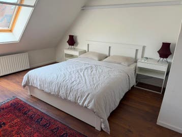 Tweepersoonsbed met hoofdbord en nachtkastjes