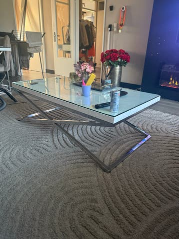Moderne salontafel met glazen blad en metalen onderstel