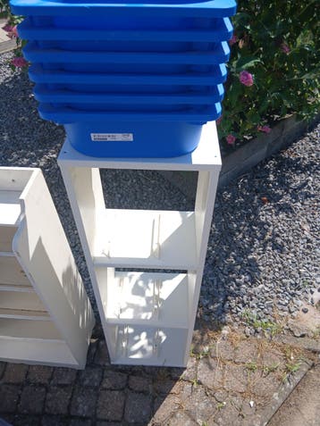 Witte smalle kast met blauwe bakken