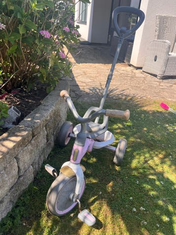 Roze driewieler met duwstang