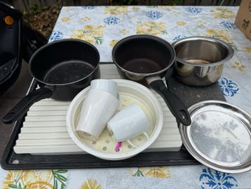 Diverse keukenspullen: pannen, bekers en afdruiprek