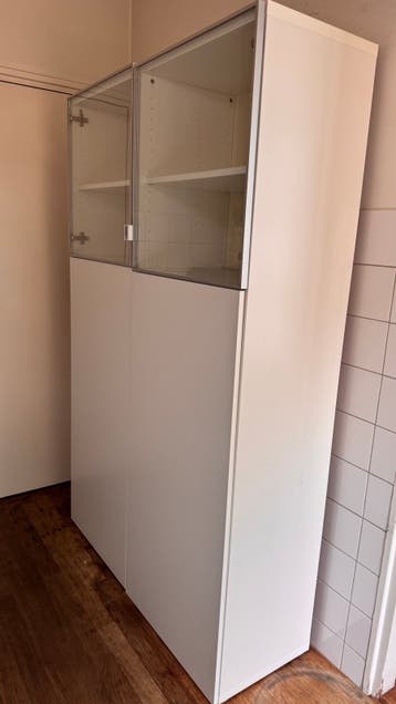 Hoge witte Ikea Besta vitrine kast met deuren en planken